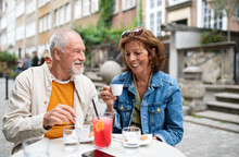 Portrait Of Happy Senior Couple Sitting And Having Coffee Outdoors In Cafe.
