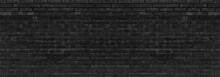 Old Black Messy Exterior Brick Wall Wide Panoramic Texture. Dark Gray Aged Masonry. Grungy Brickwork Widescreen Backdrop. Abstract Grunge Industrial Background