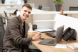 © Olga - young handsome manager working in the office on a laptop