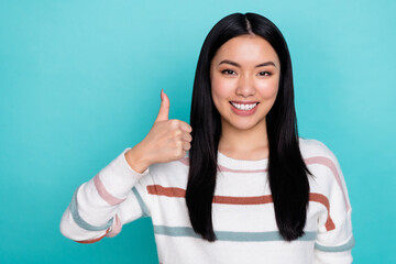 Poster - Photo of good mood korean girl showing thumb-up promote you product isolated on teal color background