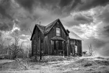 An Old Black And White Abandoned Spooky Looking Farmhouse In Winter On A Farm Yard In Rural Ontario, Canada