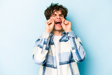 Young caucasian man isolated on blue background whining and crying disconsolately.