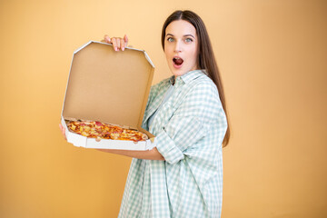 Wall Mural - Excited young woman holding hot pizza in box