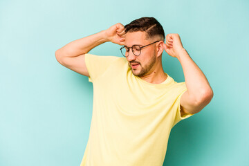 Young hispanic man isolated on blue background celebrating a special day, jumps and raise arms with energy.