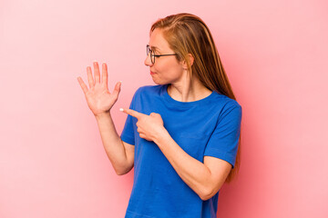 Young caucasian woman isolated on pink background smiling cheerful showing number five with fingers.