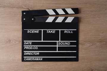 movie clapper on wooden table background ; film, cinema and video photography concept