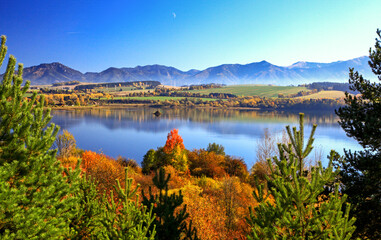 Wall Mural - Autumn trees and mirror reflection of mountains in lake