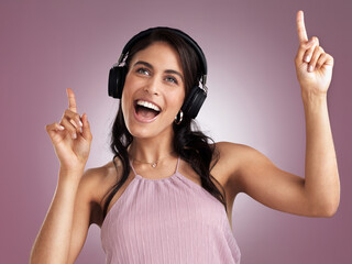 Sticker - Dancers dont need wings to fly. Shot of a beautiful young woman pointing up while listening to music wearing headphone against a pink background.