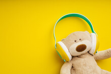 Teddy Bear With Stereo Headphones On Yellow Background