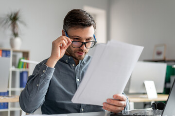 Aufkleber - Concerned mature businessman in eyeglasses reading documents at workplace in office, checking annual reports