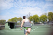© Caia Image - Woman playing tennis on sunny tennis court