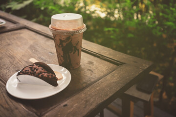 Ice Mocca on wood table , Coffee cup plastic under sunshine morning .