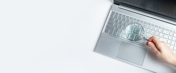Poster - Banner with woman hand holding magnifying glass over laptop keyboard. Information search on Internet concept. Expertise of electronic projects, financial data. Space for text. High quality photo