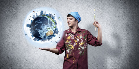 Young artist holding earth globe on hand.