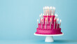 Leinwandbild Motiv Extravagant pink tiered birthday cake with lots of gold birthday candles