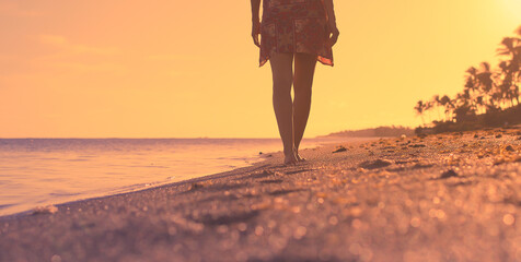 Poster - Female walking along the beach at sunset 