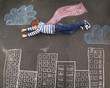 Whatever you can imagine.... Top view of a young boy using chalk and imagination to create his own world.