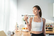 Asian beautiful woman in sportswear drink water after exercise at home