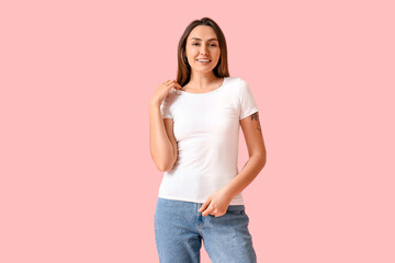 Young woman in blank t-shirt on color background