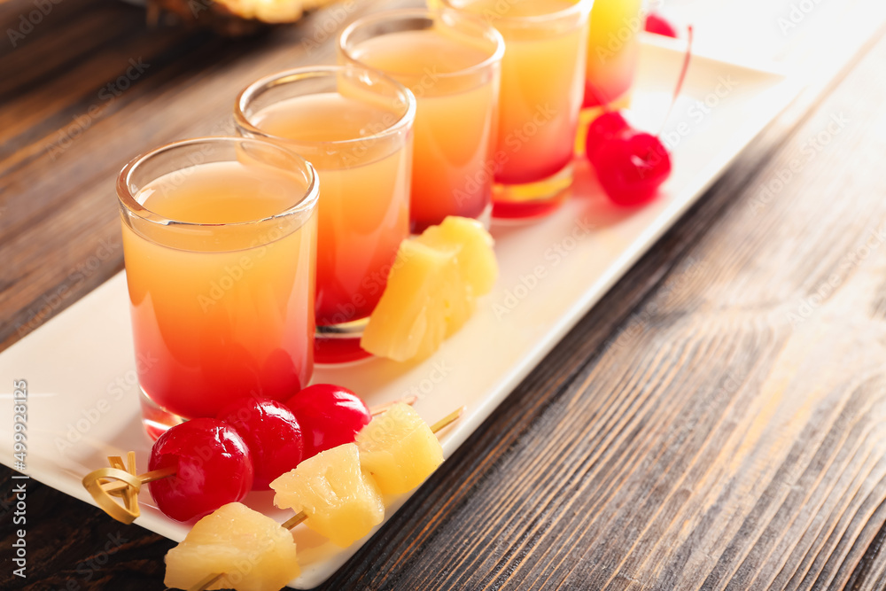 Plate with tasty Pineapple Upside Down Cake Shots on wooden background, closeup