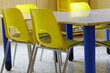 yellow classroom chairs inside the school without children during recess
