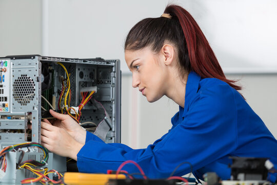 female technician repairing dismantled computer