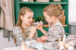 happy family candid little kids sisters girls together playful pinkie swear and have fun ready and waiting springtime Easter holiday at home in kitchen decorated table for lunch or dinner