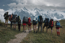A Group Of Tourists With Backpacks Admire The View Of The Main Ridge Of The Caucasus, Svaneti, Georgia