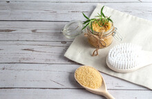 Brown Sugar Scrub With Oil On Napkin With Massage Brush And Sugar On Spoon, Wooden Background, Copy Space
