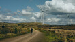 © Andre Silva - Woman running near wind turbine in the countryside