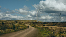 Woman Running Near Wind Turbine In The Countryside