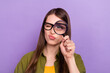 Portrait of attractive skeptic girl holding loupe looking search check isolated over violet purple color background