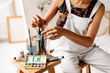 © (JLco) Julia Amaral - Unrecognizable female painter picking a brush from a jar