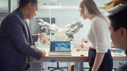 Leinwandbilder - Diverse Computer Science Specialists Standing Near Black Chief Engineer and Developing Programme for Motion of Robotic Arm. Education and Innovative Technologies Concept. Moving Shot