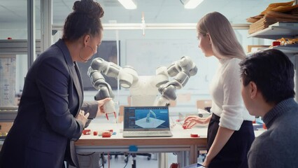 Leinwandbilder - Black Professor analysis and Discuss Futuristic Robotic Arm with Two Diverse Young Specialists at Research Laboratory with Laptop. Engineer Helping to People. Computer Science Concept. Slow Motion