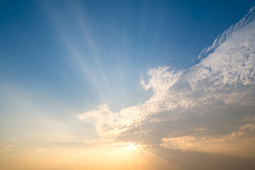 sunset / sun rise sky with rays of light shining clouds and sky background and texture