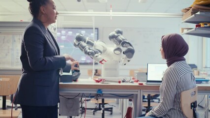 Aufkleber - Arabic Future Engineer Ask Female Professor while Developing Programme for Automated Robotic Systems. Black Woman Manipulating Robot Arm. Autonomous Facility Optimisation Concept