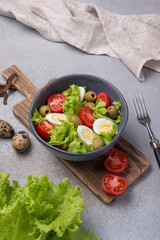 Wall Mural - Healthy salad with fresh lettuce, cherry tomatoes, quail egg and olives in bowl