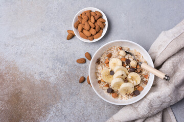 Wall Mural - Healthy breakfast with oatmeal, nuts, banana and chocolate drops