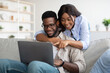 © Prostock-studio - Portrait of African American couple using computer in living room