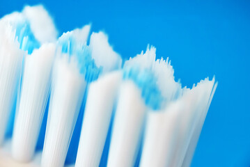 Electric ultrasonic toothbrush bristles on blue background.