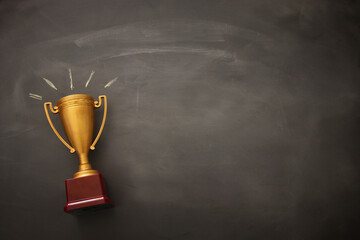 Wall Mural - golden trophy over blackboard background. top view. flat lay.