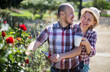 © caftor - woman and man look after roses in the garden