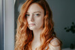 © ADDICTIVE STOCK - Sad redhead woman looking at camera in room