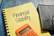 Closeup shot of a yellow notebook page with the writing financial stability