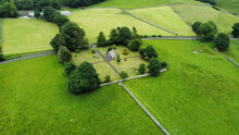 Aerial Shot Of Ingleton Cemetery And Chapel Surrounded By Greenery Fields And Trees