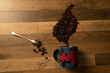 © 27 Inc/Wirestock Creators - Top view of coffee beans in a decorative style with a blue mug and a spoon on parquet floor