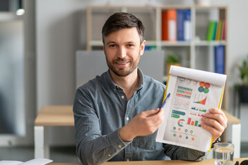 Poster - Online meeting concept. Mature businessman having video call, showing diagrams to laptop camera, sitting in office