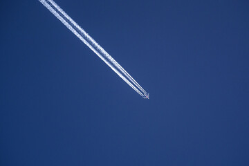 Wall Mural - Photo of a plane with condensation tracks