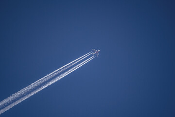 Photo of a plane with condensation tracks